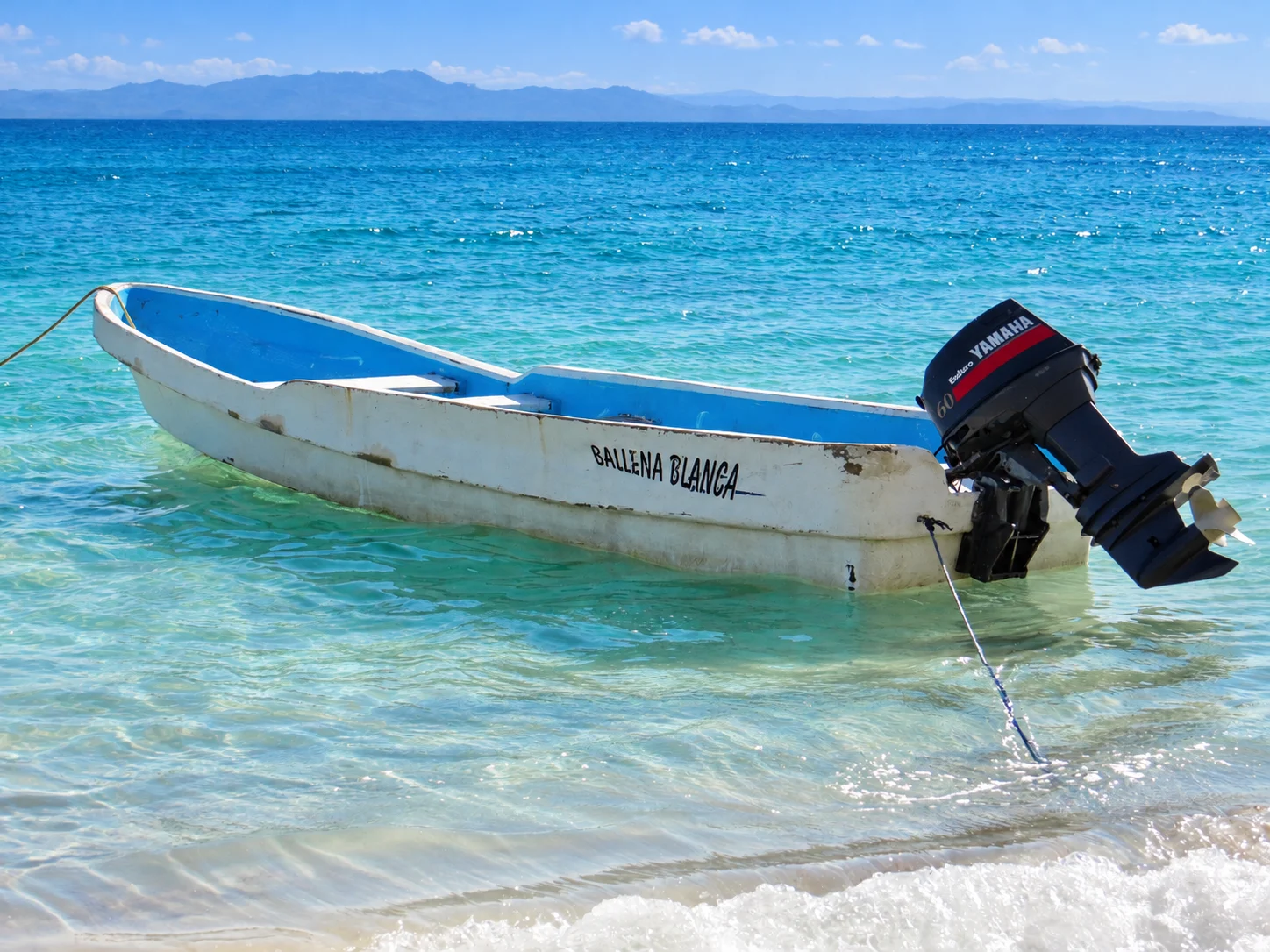 A blue-interior local boat at the sandy waterline — Cayo Levantado, AI-enhanced archival photograph